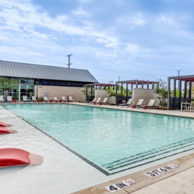 Resort-style swimming pool a swimming pool with lounge chairs around it