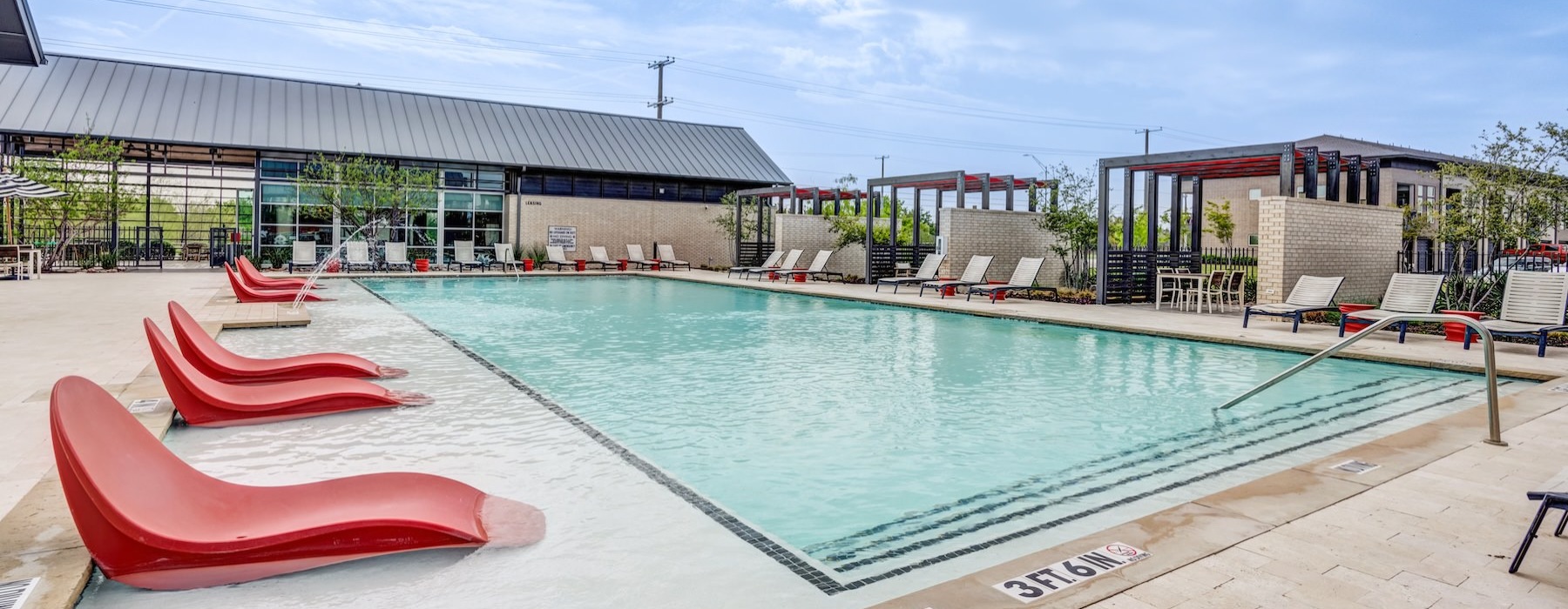 a swimming pool with lounge chairs around it