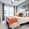 a bedroom with a bed, a dresser and a window