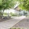 a brick walkway with benches and trees